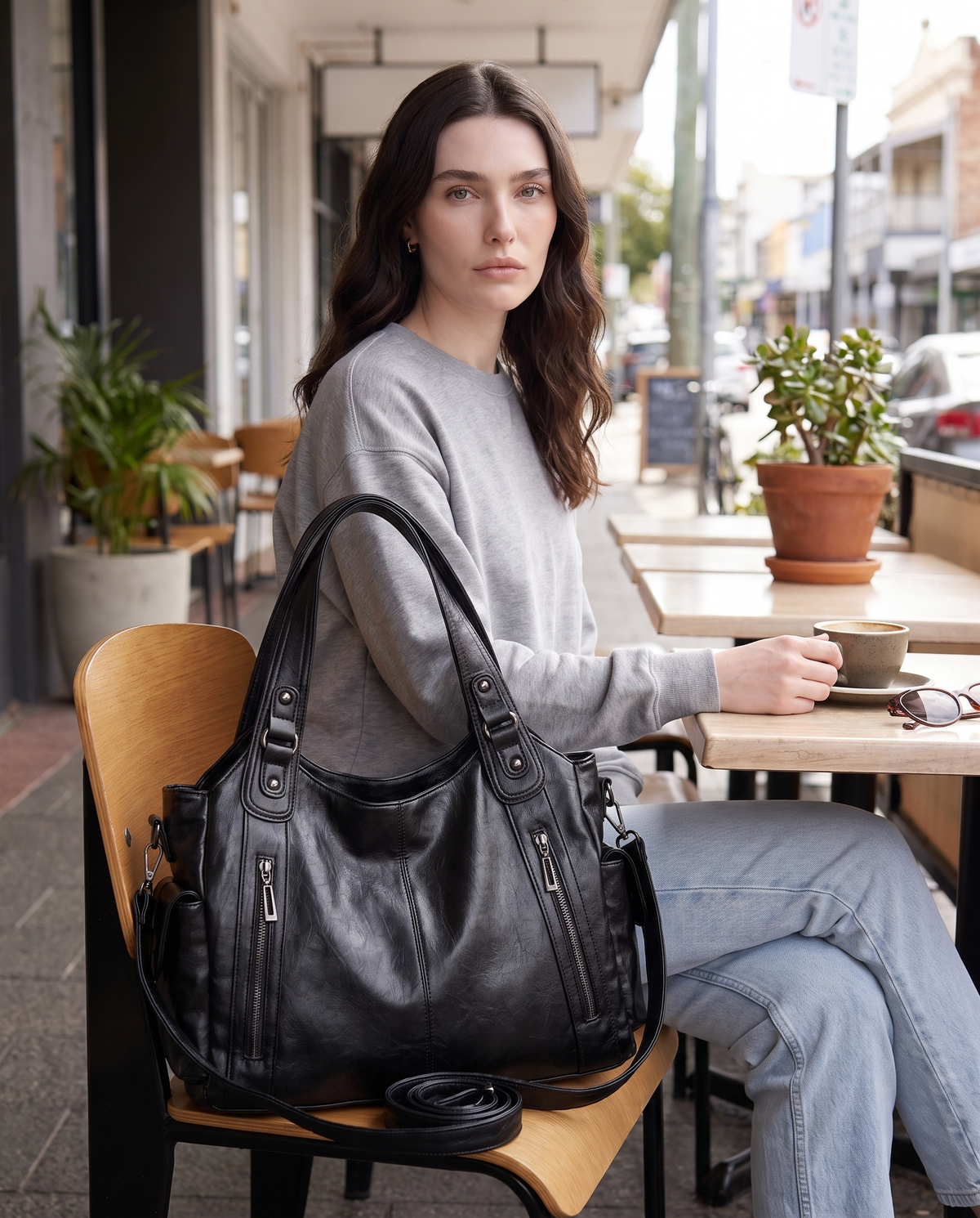 Mujer sentada con el bolso Carolina negro